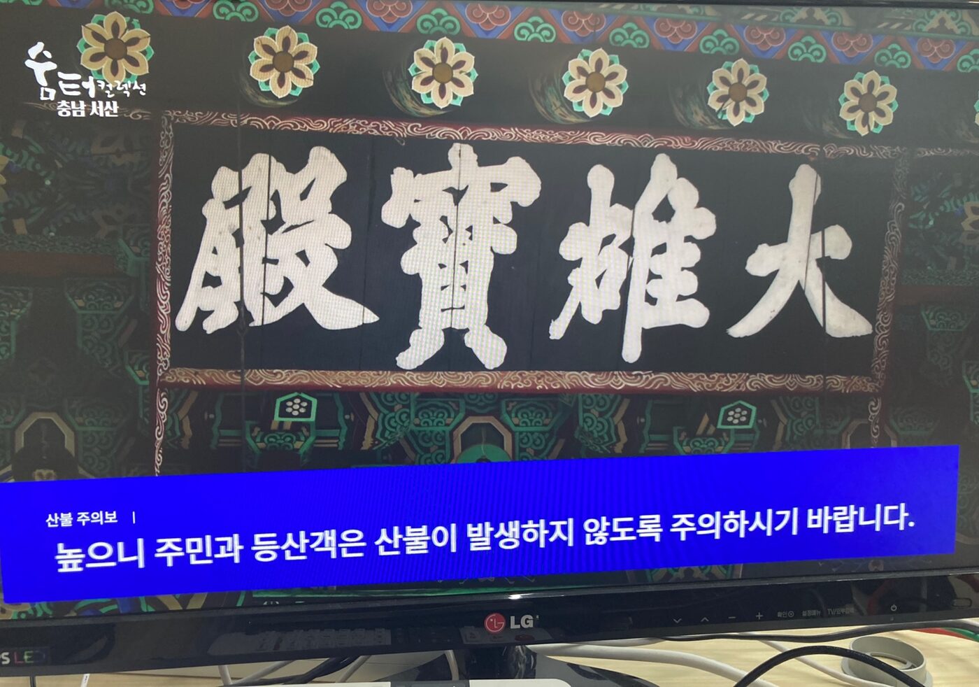 TV 화면 아래에 산불 주의보 자막이 흐르는 모습
